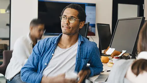 IT worker leaning on his desk with a coffee
